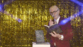 a man in a red suit is reading a book titled the best coffee