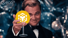 a man in a tuxedo is holding a wine glass and a coin with a cube on it