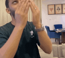 a man wearing a kia shirt covering his mouth with his hands