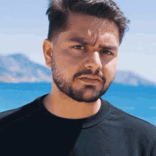 a man with a beard wears a black shirt