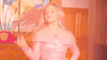 a woman in a pink dress is dancing in front of a painting