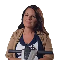 a woman in a tan sweater is sitting on a white scooter