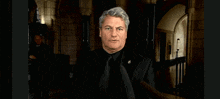 a man in a black suit has a badge on his chest that says ' a '