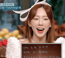 a woman in a white dress is smiling and holding a sign that says twist king