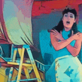 a woman in a blue shirt is standing in front of a yellow ladder