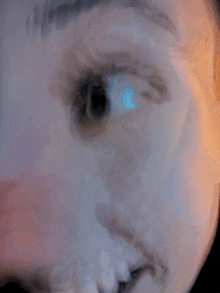 a close up of a person 's eye with a blue light shining through it