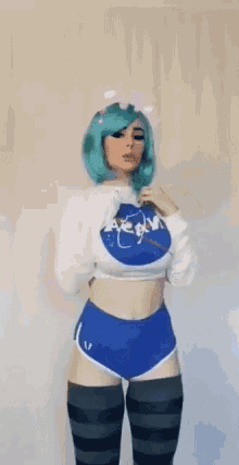 a woman with blue hair is wearing a nasa sweatshirt and shorts .