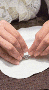 a close up of a person 's hands holding a ring