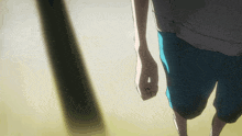 a person in blue shorts and a white shirt is walking on a sandy surface
