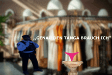 a police officer stands in front of a rack of clothes with the words " genau den tanga brauch ich " on the bottom