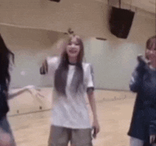 a group of young women are dancing in a room .