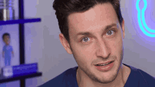a man in a blue shirt looks at the camera