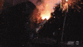 a man holding a gun with a tnt logo in the background