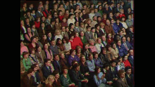 a large crowd of people are sitting in a stadium