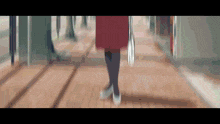 a woman in a red dress and black tights is walking down a hallway