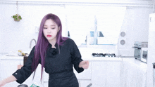 a woman with purple hair is standing in a kitchen
