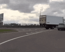 a white truck is driving down a highway next to a white car