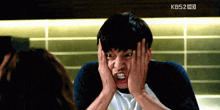 a man is making a funny face in front of a kbs2 hd screen