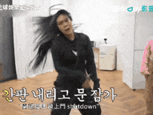 a woman with long hair is dancing in a room with chinese writing on the wall