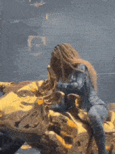 a woman playing a saxophone while sitting on a gold motorcycle