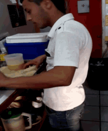 a man in a white shirt is standing at a counter