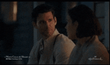 a man and a woman are sitting next to each other on a hallmark screen