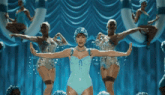 a woman in a blue bathing suit is surrounded by other women in blue bathing suits