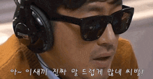 a man wearing sunglasses and headphones with korean writing on the bottom right