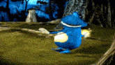 a blue cartoon character is standing in the grass .