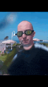 a man wearing swimming goggles is standing in front of a pool .