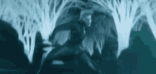 a man is standing in the middle of a forest holding a sword .