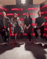 a group of people are sitting in front of a smirnoff sign