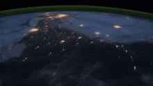 an aerial view of the earth at night with lights visible