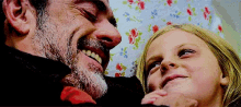 a man with a beard and a little girl are smiling and looking at each other