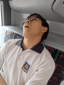 a man wearing glasses and a white shirt with a crest that says ' singapore ' on it
