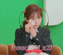 a girl holding a cell phone with the words touched x2 written below her