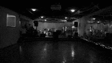 a black and white photo of a band playing in an empty room