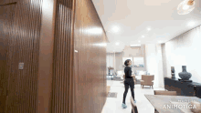 a woman is walking through a living room with the words made in animotica on the bottom