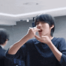 a man in a blue shirt is eating something with his finger