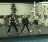 three women are dancing in front of a sign that says pinoy big br