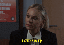 a woman says i am sorry in front of a poster that says probably nothing out