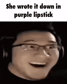 a man wearing glasses and headphones is smiling while holding a purple lipstick .