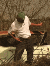 a man wearing a white golf shirt is dancing in front of a car