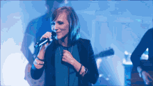 a woman singing into a microphone on stage