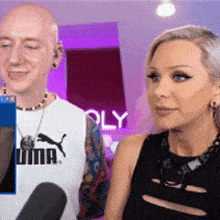 a man and a woman are standing next to each other with the word puma on their shirt