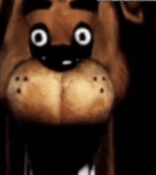 a close up of a teddy bear 's face with big eyes and sharp teeth .