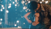 a man and a woman are kissing in front of a crowd of people .