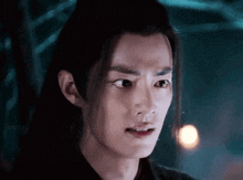 a close up of a man 's face with long hair making a funny face .