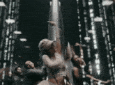 a group of women are dancing in a dark room with a blurred background