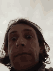 a close up of a person 's face with a gray background